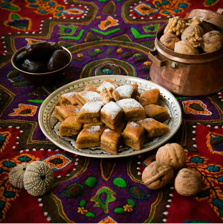 Komach Sehen diamond-cut date pastries on patterned Persian tablecloth